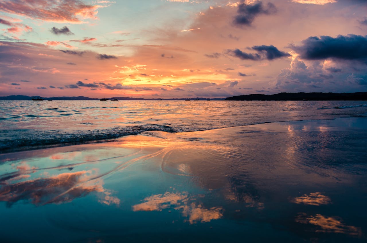 gallery-2 Stunning sunset over the ocean with vibrant reflections on a tranquil beach.