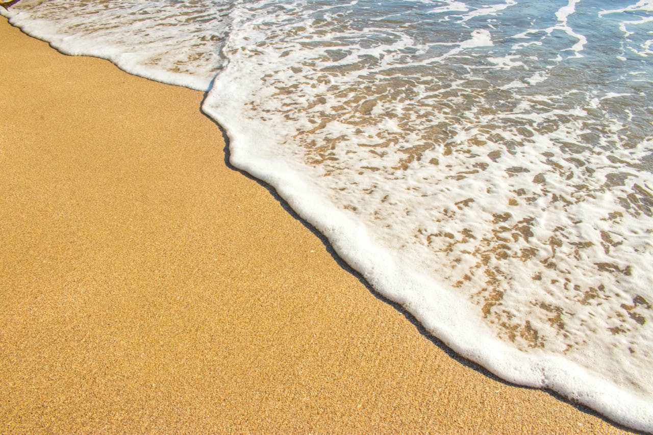 gallery-6 Peaceful beach scene showing sand meeting ocean waves in Puntarenas, Costa Rica.